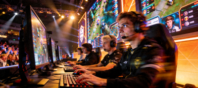 电竞比赛现场，选手在电脑前激烈操作，背景有大屏幕